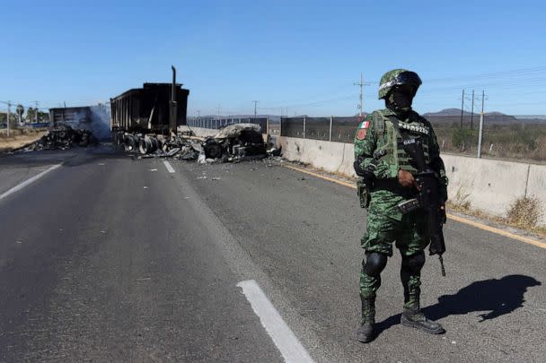 PHOTO: A soldier keeps watch near the wreckage of a vehicle set on fire by members of a drug gang, following the detention by Mexico of gang leader Ovidio Guzman in Culiacan, in Mazatlan, Mexico, Jan. 5, 2023. (Stringer/Reuters)