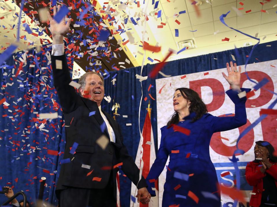 Doug Jones y su esposa saludan a sus seguidores antes de dar un discurso en Birmingham, Alabama, en una fiesta en la que celebran la victoria la noche de las elecciones. (John Bazemore/AP)