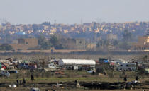 Islamic state members walk in the last besieged neighborhood in the village of Baghouz, Deir Al Zor province, Syria February 18, 2019. REUTERS/Rodi Said