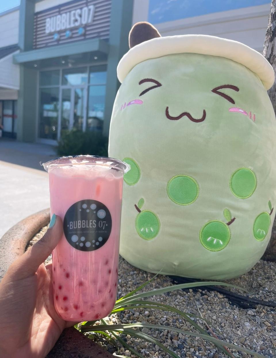 Strawberry bubble tea with a plushie, in front of Bubbles 07 in Brick.