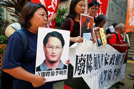 Pro-democracy protesters carry a photo of detained Taiwanese rights activist Lee Ming-Che (L) and other activists during a demonstration in Hong Kong, China September 11, 2017. REUTERS/Bobby Yip