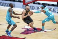 Chicago Bulls' Nikola Vucevic, center, drives to the basket between Charlotte Hornets' Devonte' Graham (4) and Bismack Biyombo during the first half of an NBA basketball game Thursday, April 22, 2021, in Chicago. (AP Photo/Charles Rex Arbogast)