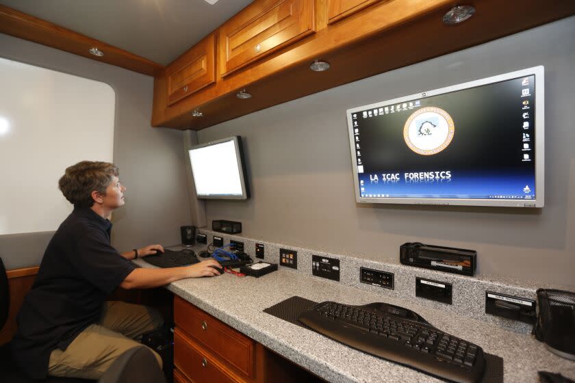 Los Angeles Police Department Internet Crimes Against Children Task Force detective Shannon Geaney demonstrates computer forensics on a hard drive at a mobile lab, after authorities throughout Southern California announce the arrests of more than 275 child predators during a news conference in Los Angeles Thursday, June 26, 2014. Law enforcement conducted the operations in Los Angeles, Orange, San Bernardino, Santa Barbara and Ventura counties. (AP Photo/Damian Dovarganes)