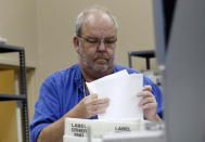 An election worker calibrates a new vote counting machine, Monday, Nov. 12, 2018, at the Broward Supervisor of Elections office in Lauderhill, Fla. The Florida recount continued Monday in Broward County. (Joe Cavaretta /South Florida Sun-Sentinel via AP)