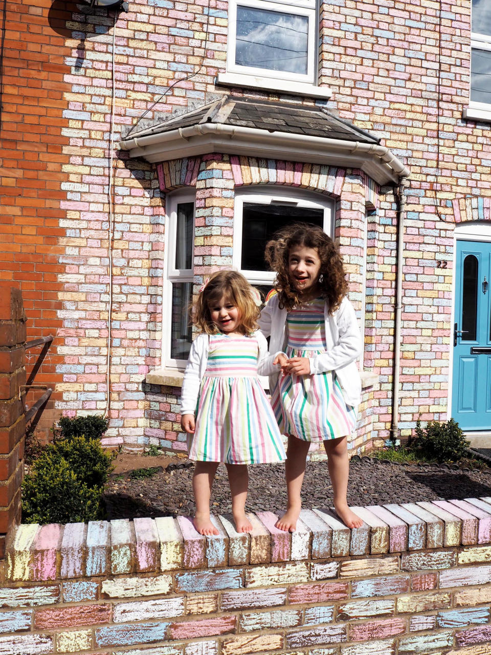 Matilda and Arabella don rainbow dresses to match their rainbow house. (SWNS)