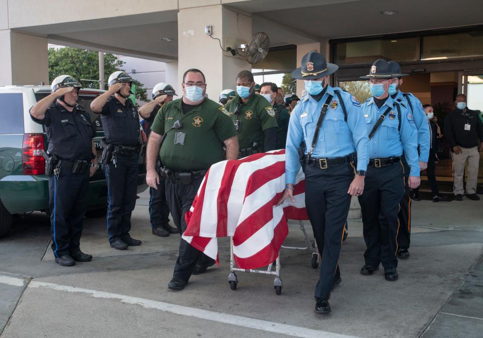 The body of Madison "Skip" Nicholson, a retired deputy with the Wilcox County Sheriff's Office in Alabama, is escorted out of Ascension Sacred Heart Hospital in Pensacola on Thursday. Nicholson was killed Wednesday in Yellow Bluff, Alabama, while responding to a domestic violence call.