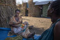 Lemlem Haylo Rada, 25, who fled the conflict in Ethiopia's Tigray region, holds her one-month old baby in front of her shelter, at Um Rakuba refugee camp in Qadarif, eastern Sudan, Monday, Nov. 23, 2020. Tens of thousands of people have fled a conflict in Ethiopia for Sudan, sometimes so quickly they had to leave family behind. There is not enough to feed them in the remote area of southern Sudan that they rushed to. (AP Photo/Nariman El-Mofty)