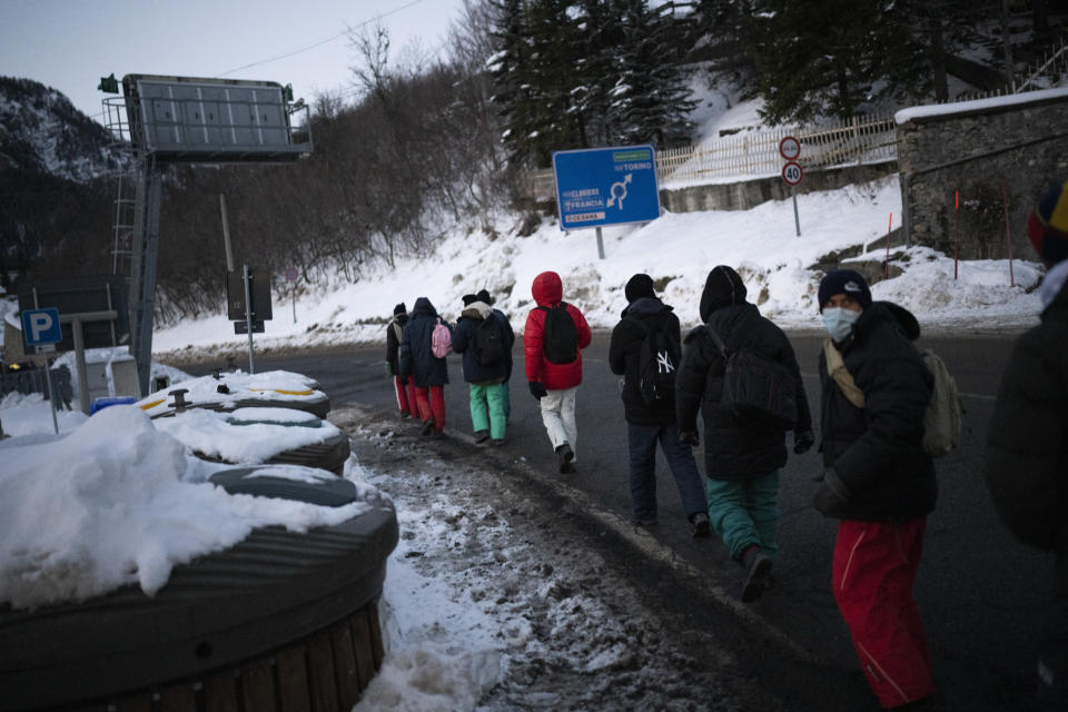 Migrantes que tratan de llenar a Francia desde Italia caminan por una carretera de montaña hacia la frontera, el sábado 11 de diciembre de 2021. (AP Foto/Daniel Cole)