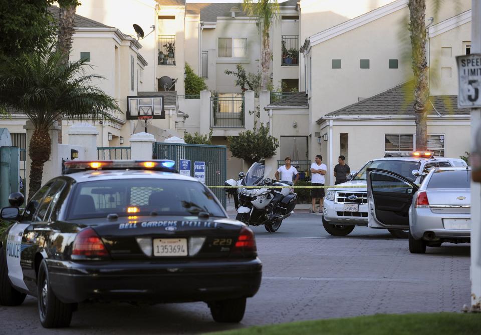 A police vehicle and residents are seen at the crime scene where mayor of Bell Gardens, California Daniel Crespo was shot, at a condominium in Bell Gardens, California September 30, 2014. Crespo was shot to death by his wife on Tuesday in an apparent domestic dispute, and his spouse has been detained by investigators, according to the county sheriff's department. The shooting stemmed from an afternoon quarrel between Crespo, 45, and his wife, Lavette, 43, that escalated when their 19-year-old son, Daniel Jr., intervened, sheriff's spokeswoman Crystal Hernandez said. REUTERS/Bob Riha (UNITED STATES - Tags: CRIME LAW POLITICS)