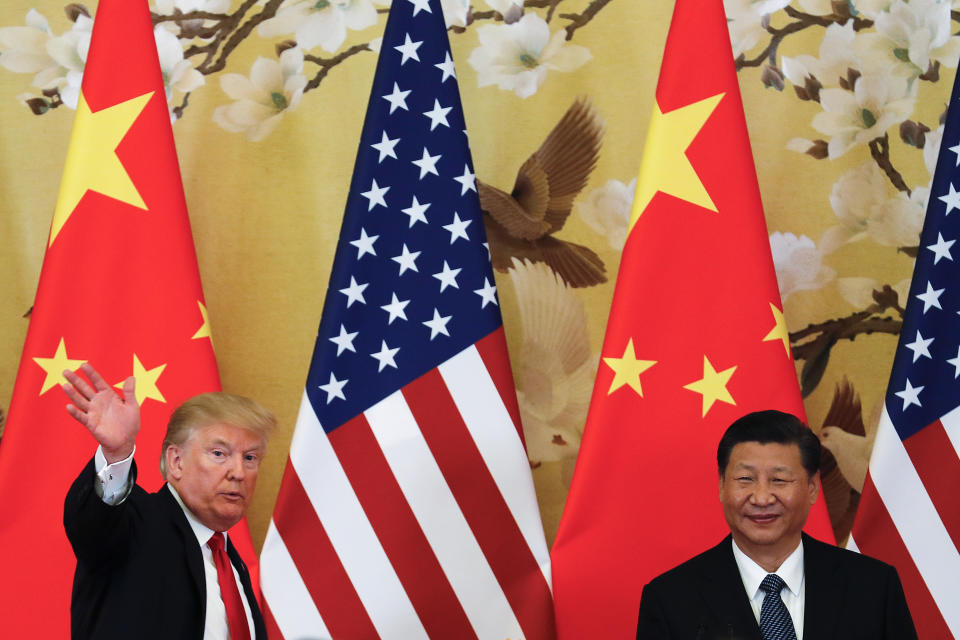 U.S. President Donald Trump waves next to Chinese President Xi Jinping. (Photo: AP Photo/Andy Wong)