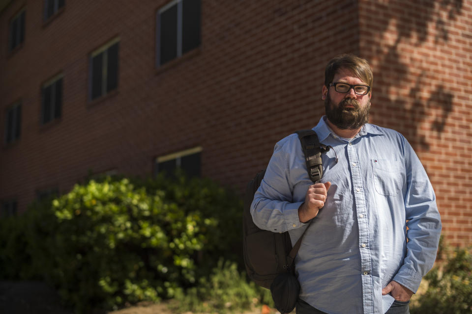 Chris Lambert, a musician and recording engineer, poses Thursday, April 15, 2021, in front of Muir Hall dormitory at California Polytechnic University in San Luis Obispo, Calif. Lambert started a podcast to document the 1996 disappearance of Kristin Smart, who was a college student at Cal Poly and lived in Muir Hall when she disappeared. On Tuesday, April 13, 2021, the San Luis Obispo County sheriff announced arrests in the 25-year-old case, crediting Lambert with helping bring in witnesses that propelled the case forward. (AP Photo/Nic Coury)