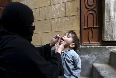 A boy receives polio vaccine drops outside his family home in Karachi, Pakistan, February 15, 2016. REUTERS/Akhtar Soomro