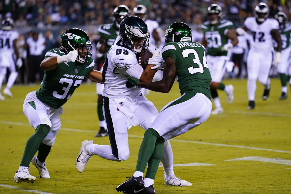 Philadelphia Eagles' Noah Togiai runs with the ball between New York Jets' Justin Hardee, right, and New York Jets' Elijah Riley during the second half of a preseason NFL football game Friday, Aug. 12, 2022, in Philadelphia. (AP Photo/Matt Rourke)