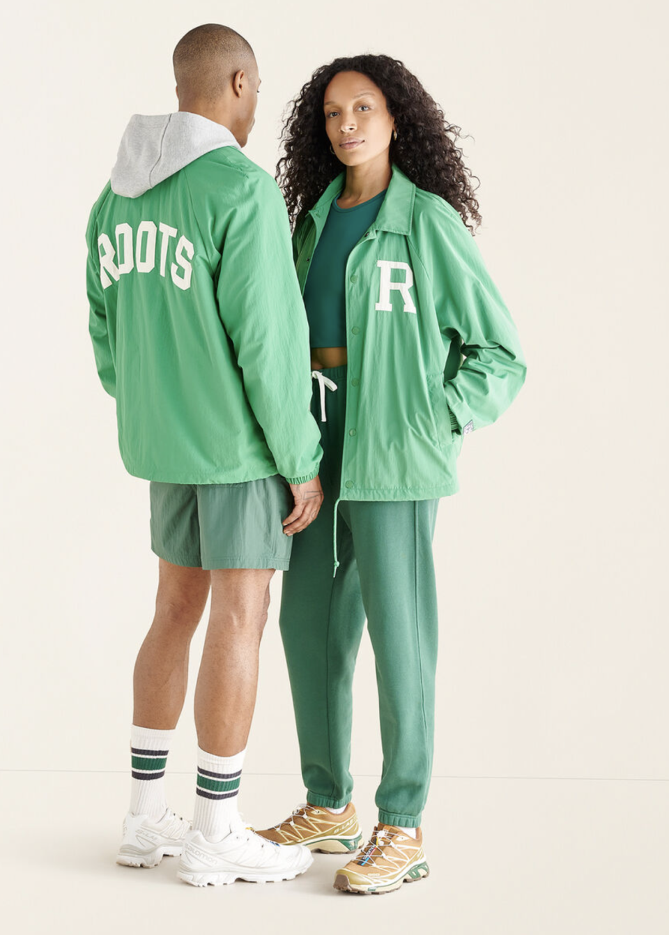 man and woman wearing matching Roots Outdoors Counselor Nylon Jacket Gender Free in Kelly Green (Photo via Roots)