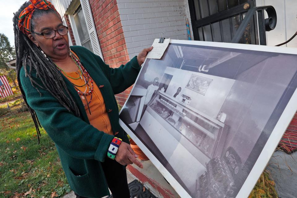 Naeemah Jackson shows an old photo of her grandparents in their sausage store that was originally at 4155 Boulevard Place in the Butler-Tarkington neighborhood. Photo taken Friday, Nov. 19, 2021.