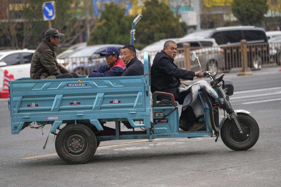 Workers sit on a three-wheeled bike on the street in Beijing, China, March 21, 2024. China’s first generation of migrant workers played an integral role in the country's transformation from an impoverished nation to an economic powerhouse. Now, they're finding it hard to find work, both because they're older and the economy is slowing. (AP Photo/Tatan Syuflana)