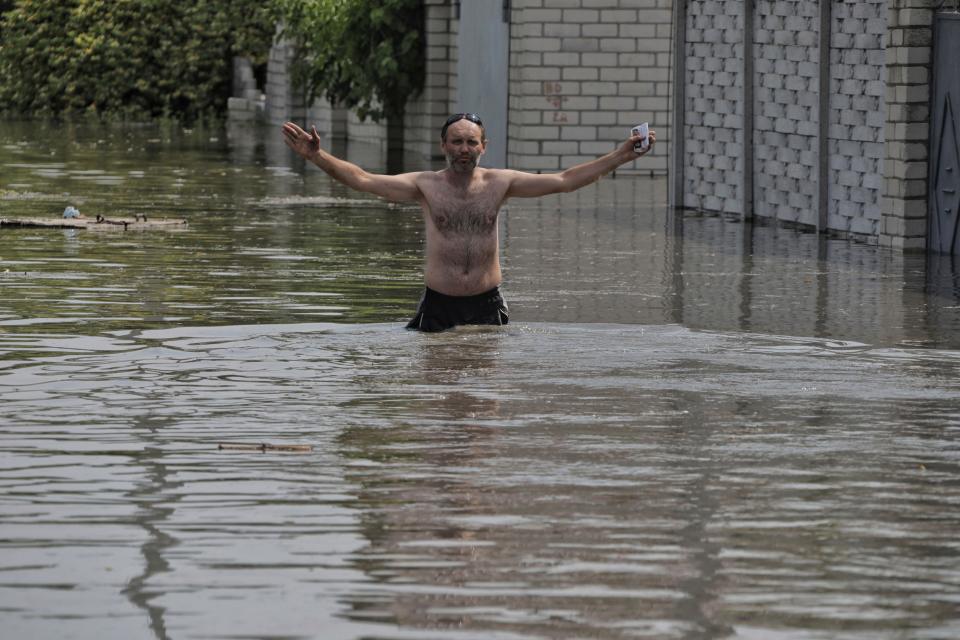 A local resident gestures near his house, which was flooded after the Russian troops blew the Kakhovka dam overnight, in Kherson, Ukraine, Tuesday, June 6, 2023. Ukraine on Tuesday accused Russian forces of blowing up a major dam and hydroelectric power station in a part of southern Ukraine that Russia controls, risking environmental disaster. (AP Photo/Nina Lyashonok)