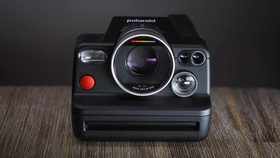 Polaroid I-2 camera on a wooden surface with dramatic lighting