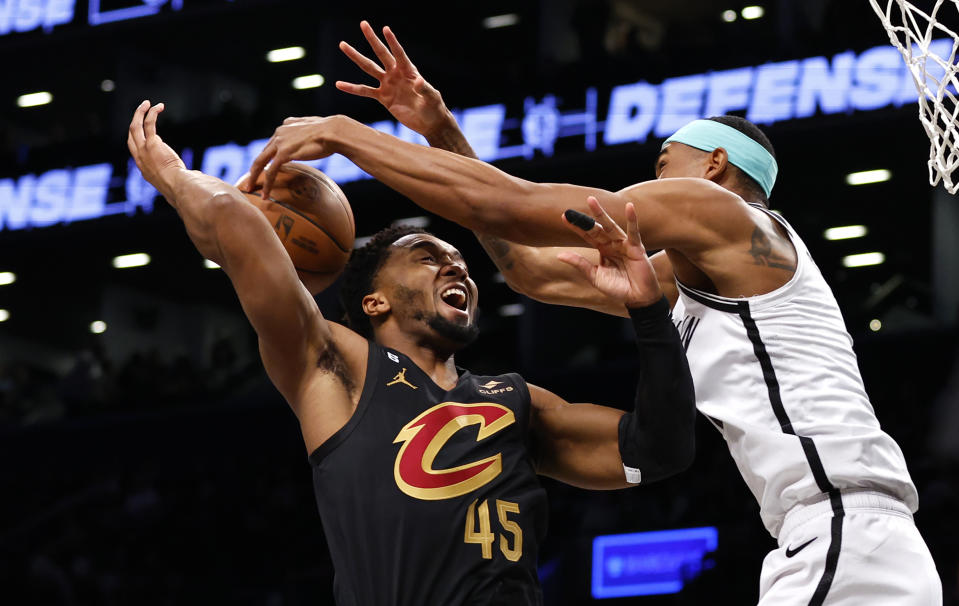 Cleveland Cavaliers guard Donovan Mitchell (45) is fouled by Brooklyn Nets center Nic Claxton during the first half of an NBA basketball game, Thursday, March 23, 2023, in New York. (AP Photo/Noah K. Murray)