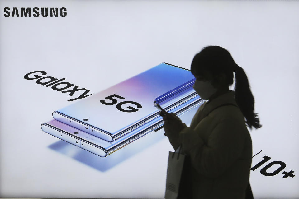 A woman passes by an advertisement of Samsung Electronics' Galaxy 5G Note10+ smartphone at a subway station in Seoul, South Korea, Thursday, Jan. 30, 2020. Samsung Electronics Co. said Thursday its operating profit for the last quarter fell 33.7% from a year earlier but it predicted earnings will improve in 2020, driven by a gradually stabilizing computer chip market and increasing 5G smartphone sales. (AP Photo/Ahn Young-joon)