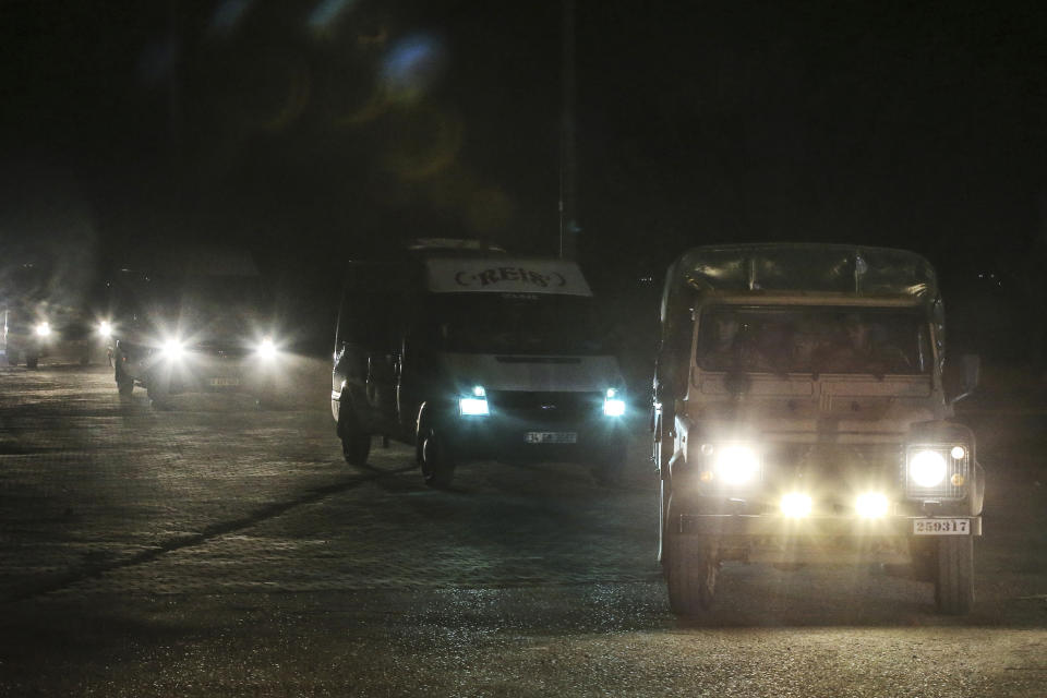 In this late Friday, Oct. 18, 2019 photo, Turkish police and army cars escort vans and buses returning from Syria, reportedly carrying IS group members and their families, at the border town of Akcakale, Sanliurfa province, southeastern Turkey. Turkey's interior minister Suleyman Soylu said Saturday, Oct. 19, that 41 Islamic State members were re-captured in Syria and private IHA news agency said the Turkish nationals among the re-captured were brought over to Turkey in vans. Turkey's President Recep Tayyip Erdogan Erdogan said the Turks captured would be imprisoned and tried in Turkey. (AP Photo/Emrah Gurel)