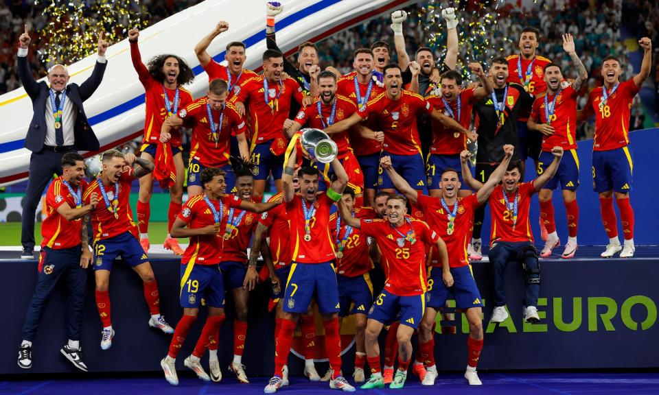 <span>Spain captain Álvaro Morata lifts the trophy with his teammates after victory over England in Berlin.</span><span>Photograph: Tom Jenkins/The Guardian</span>