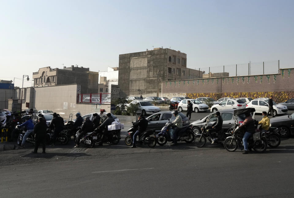 Motorcycles and cars line up outside a gas station in Tehran, Iran, Monday, Dec. 18, 2023. Nearly 70% of Iran's gas stations went out of service on Monday following possible sabotage — a reference to cyberattacks, Iranian state TV reported. (AP Photo/Vahid Salemi)