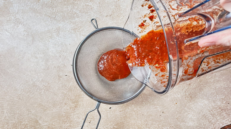pouring sauce into strainer