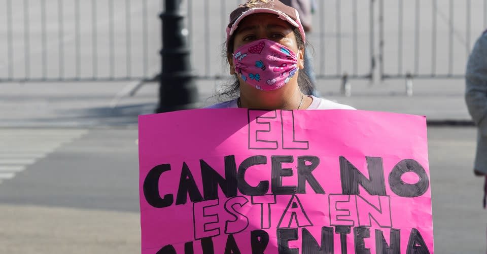 Mujer con pancarta en protesta por desabasto de medicamentos para el cáncer