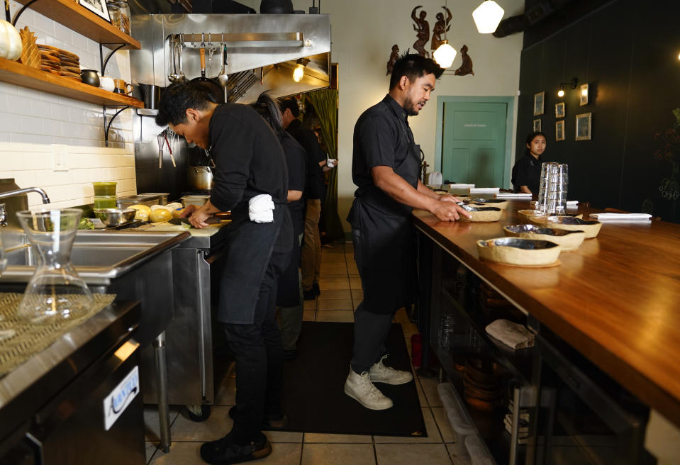 Chef Aaron Verzosa of Filipino American restaurant Archipelago, right, works in the kitchen Wednesday, May 24, 2023, in Seattle. Verzosa is nominated for a 2023 James Beard Award in the Best Chef: Northwest and Pacific category. (AP Photo/Lindsey Wasson)