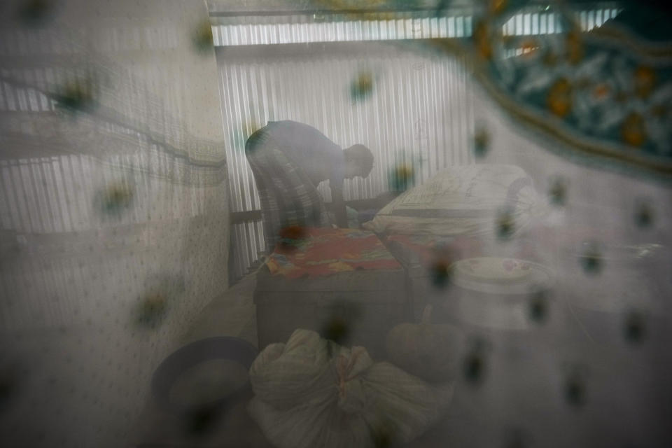 Musikur Alam arranges some materials in his house in Sandahkhaiti, a floating island village in the Brahmaputra River in Morigaon district, Assam, India, Thursday, April 25, 2024. (AP Photo/Anupam Nath)