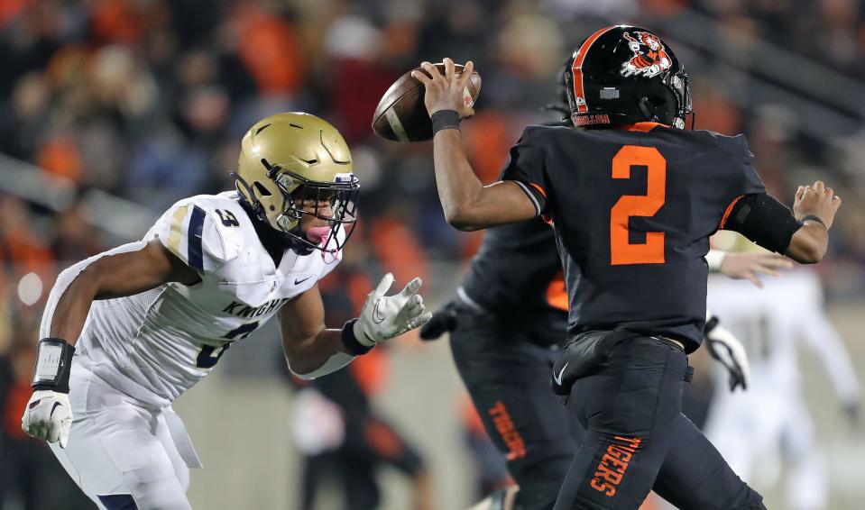 Hoban linebacker Rickey Williams, left, rushes to Massillon quarterback Jalen Slaughter during an OHSAA Division II state semifinal Nov. 25, 2022, in Akron.