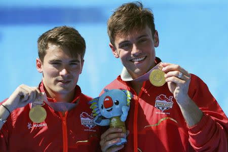 Diving - Gold Coast 2018 Commonwealth Games - Men's Synchronised 10m Platform Final - Optus Aquatic Centre - Gold Coast, Australia - April 13, 2018. Tom Daley and Dan Goodfellow of England hold up their gold medals. REUTERS/Athit Perawongmetha