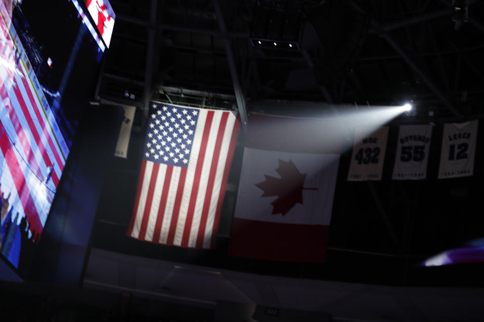 American flag illuminated during playing go the National Anthem in the first period of an NHL hockey game Tuesday, Jan. 2, 2018, in Denver. (AP Photo/David Zalubowski)
