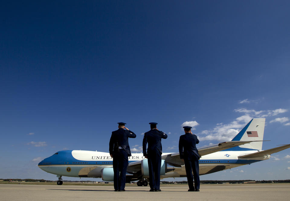 Military personnel salute Air Force One
