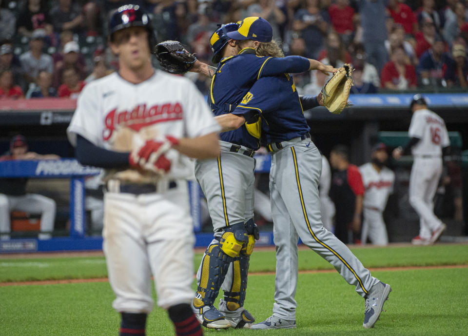 Milwaukee Brewers relief pitcher Josh Hader right, hugs catcher Omar Narvaez as Cleveland Indians' Myles Straw walks off the field after the final out of a baseball game in Cleveland, Saturday, Sept. 11, 2021. Hader combined with starting pitcher Corbin Burnes for a no-hitter. (AP Photo/Phil Long)