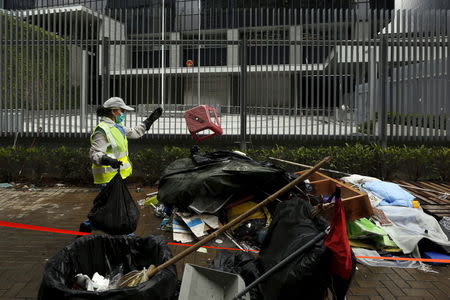 A cleaner removes encampments outside the government headquarters in Hong Kong, China June 24, 2015. REUTERS/Bobby Yip