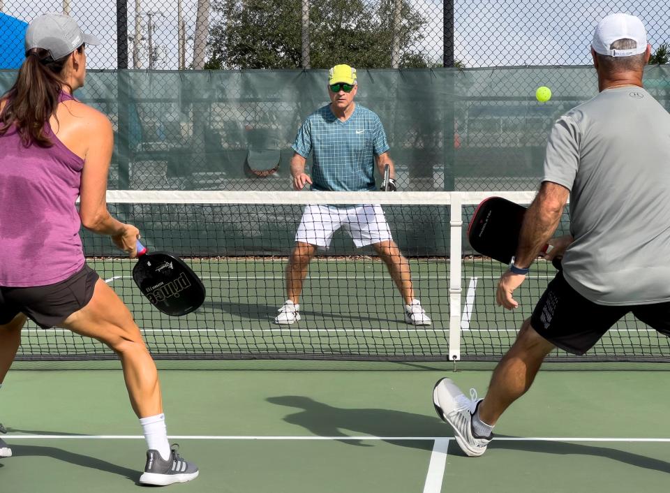 Frank Cerabino, left, plays pickleball with Paige Morris and Chip Rogers of West Palm Beach at the courts in Lake Lytal Park in West Palm Beach Tuesday, December 14, 2021. Frank has written a book about pickleball and his addiction to the sport.