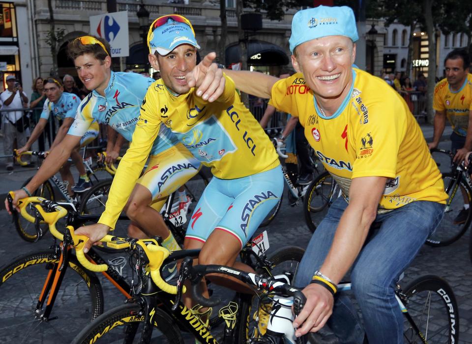 Astana team rider Vincenzo Nibali (L) of Italy celebrates with team manager Alexandre Vinokourov of Kazakhstan as they parade to celebrates his overall victory after the 137.5 km final stage of the 2014 Tour de France, from Evry to Paris Champs Elysees, July 27, 2014. REUTERS/Jean-Paul Pelissier (FRANCE - Tags: SPORT CYCLING)