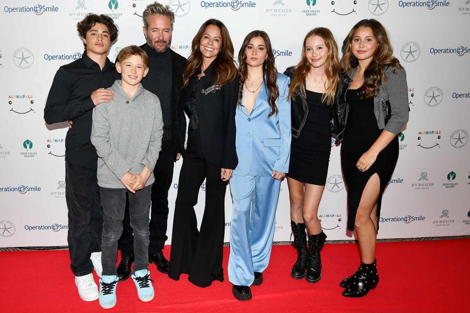 <p>Alex Goodlett/Getty Images</p> Brooke Burke and fiancé Scott Rigsby pose in Park City, Utah with five of their six respective children