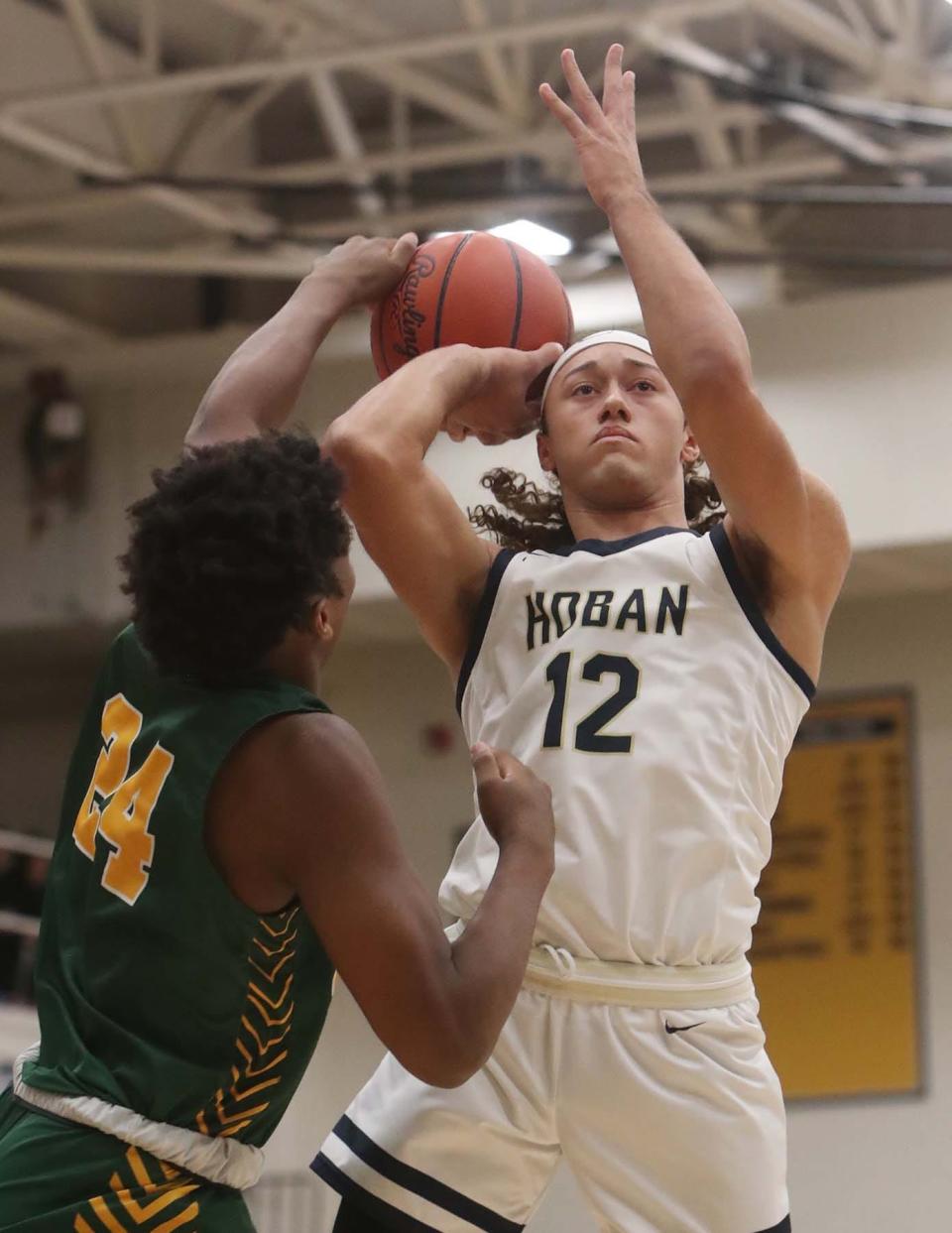 Lakewood St. Edward's Wendell Henry, left, slaps the ball away from Archbishop Hoban's Jayvian Crable during the first quarter of their Division I regional final Saturday at Copley. St. Edward won 63-46. [Karen Schiely/Beacon Journal]