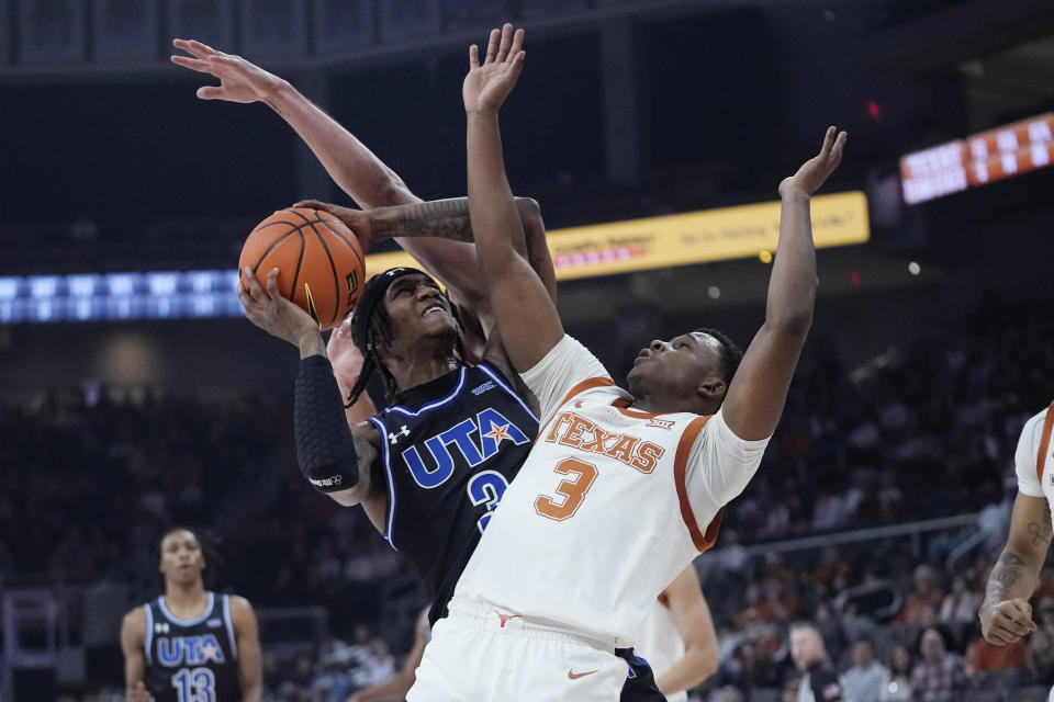 Texas-Arlington guard DaJuan Gordon, left, drives to the basket against Texas guard Max Abmas, right, during the first half of an NCAA college basketball game in Austin, Texas, Monday, Jan. 1, 2024. (AP Photo/Eric Gay)