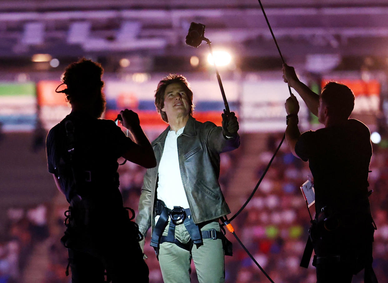 Tom Cruise takes a selfie on the roof of the Stade de France.