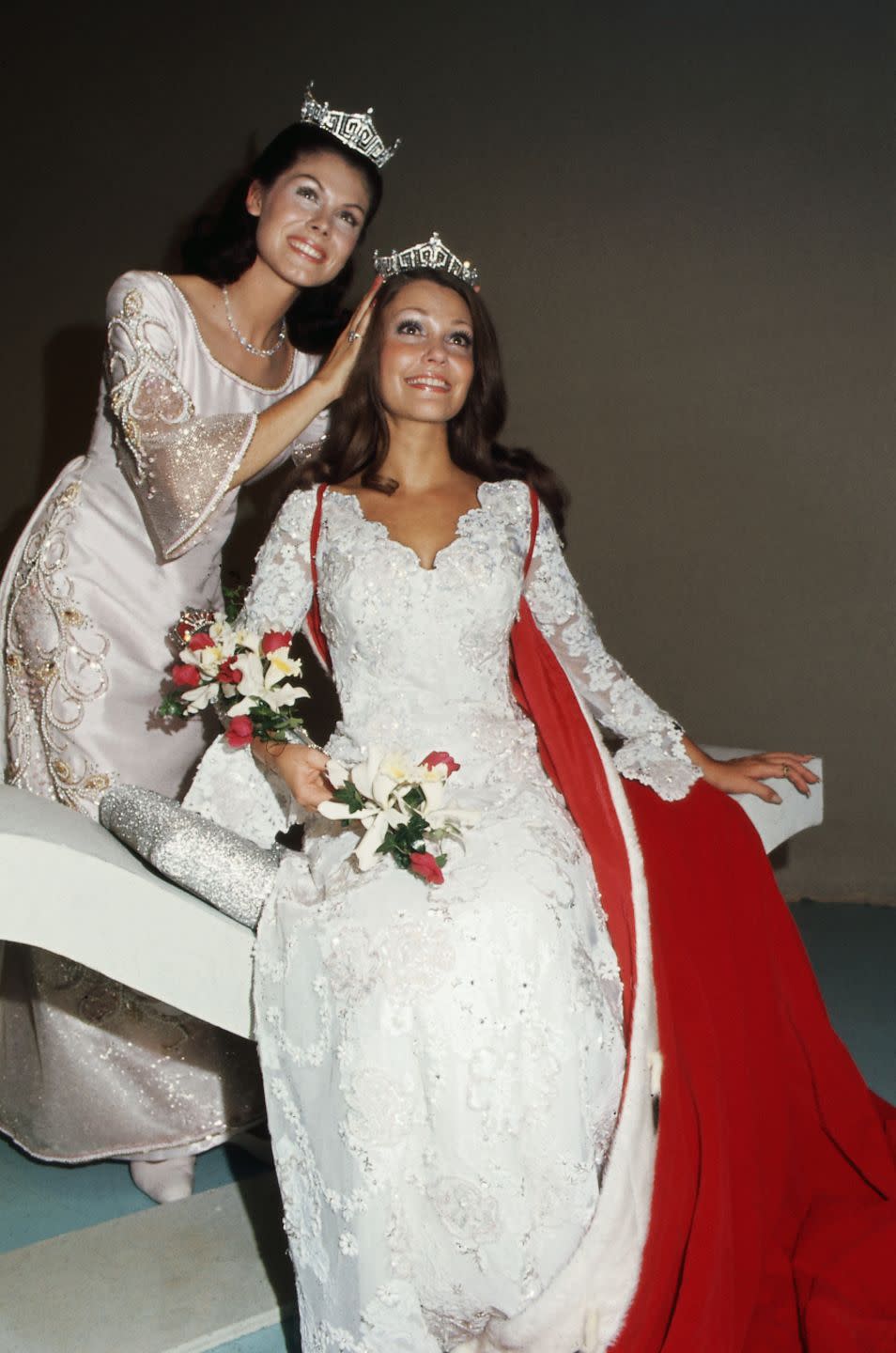 <p>Terry Meeuwsen from Wisconsin, pictured here being crowned, opted for a lace bell-sleeve dress for her evening gown. The flowing design perfectly embodied the style of the '70s. </p>