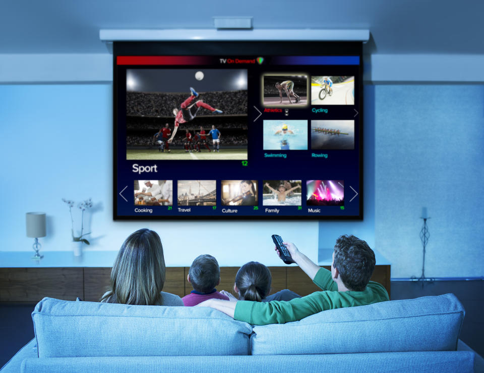 Family watching television in living room