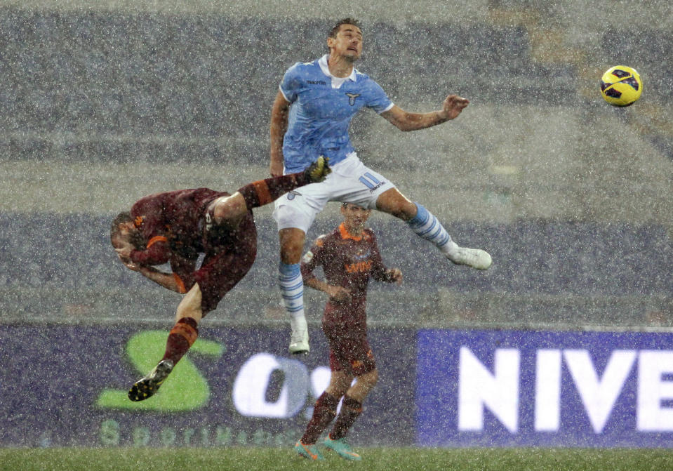 AS Roma's Daniele De Rossi (L) jumps for the ball with SS Lazio's Miroslav Klose during their Italian Serie A soccer match at the Olympic stadium in Rome November 11, 2012. Lazio won 3-2. REUTERS/Alessandro Bianchi (ITALY - Tags: SPORT SOCCER)