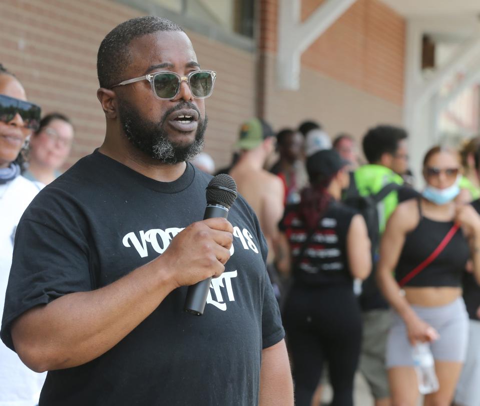 Raymond Green Jr., executive director of The Freedom BLOC, talks with protesters Monday after marching along Howard Street  in Akron.
