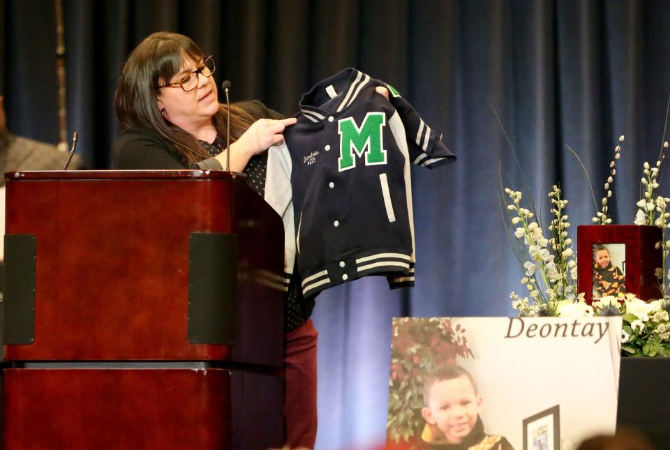 Madison STEAM Academy Principal Amanda Choinacky holds up one of two letter jackets that will hang in the school in memory of two Smith children Monday, Feb. 5, 2024, at a memorial service at Century Center in South Bend for the six Smith family children killed as a result of the Jan. 21, 2024, fatal house fire on North LaPorte Avenue. The jackets were for students Davida and Demetris.