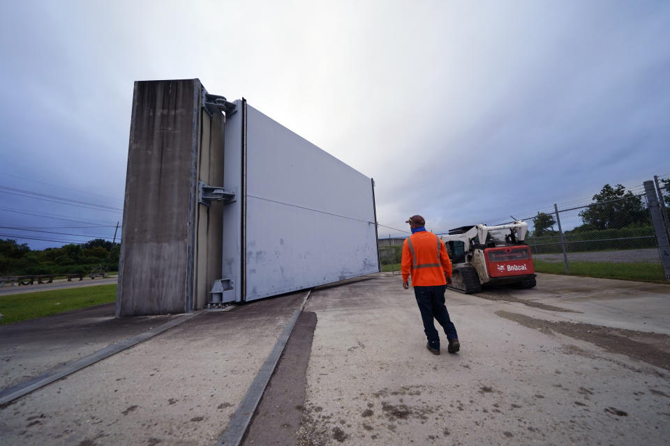 Workers for the Southeast Louisiana Flood Protection Authority - West close floodgates in Harvey, La., just outside New Orleans, Monday, Aug. 24, 2020, in advance of Tropical Storm Marco, expected to come near the Southern Louisiana coast. (AP Photo/Gerald Herbert)