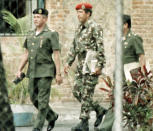 Hugo Chavez is escorted by military intelligence officers after being arrested for trying to overthrow Venezuela's government in a bloody coup, 1992. He spent two years in prison before he was granted a pardon (AP Photo/Andres Leighton)